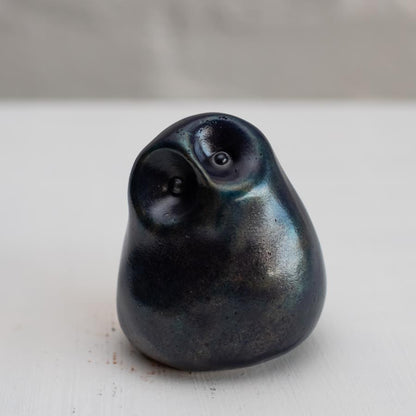 Deep blue small bronze owl sculpture on a white background