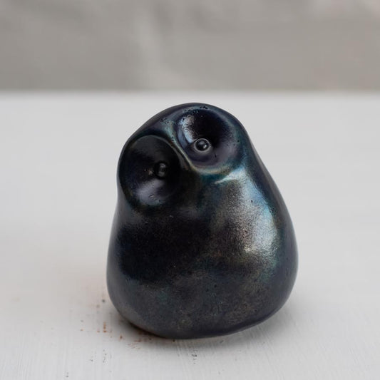 Deep blue small bronze owl sculpture on a white background