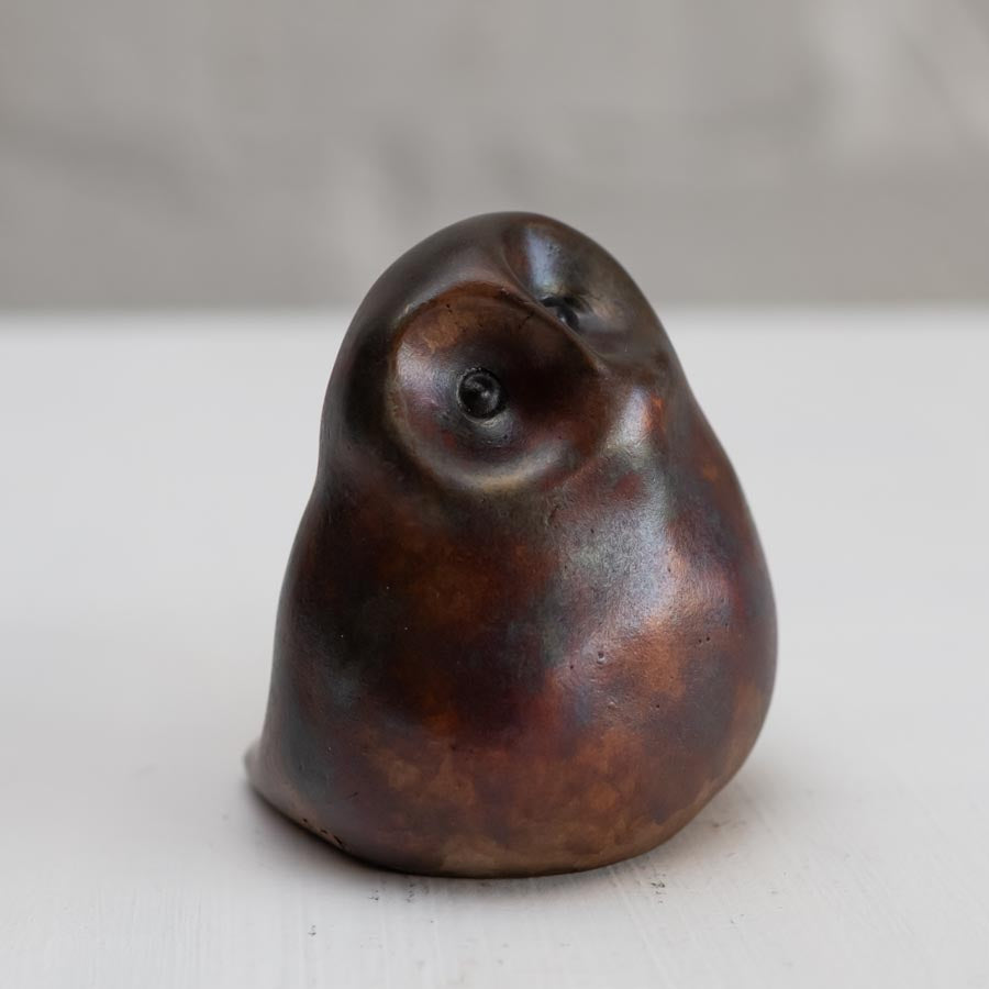 Brown coloured bronze owl sculpture against a white background