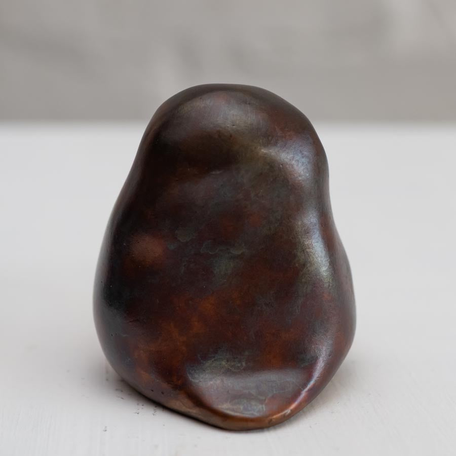 Brown coloured bronze owl sculpture against a white background - rear view