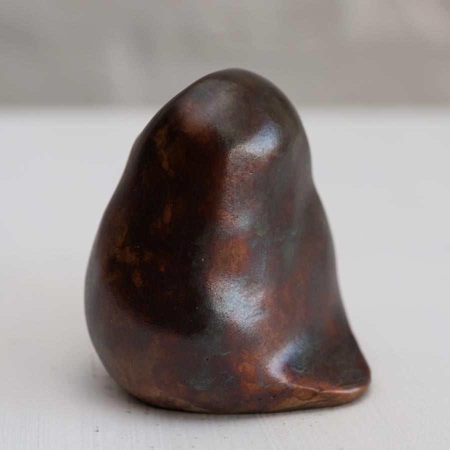 Brown coloured bronze owl sculpture against a white background - rear view