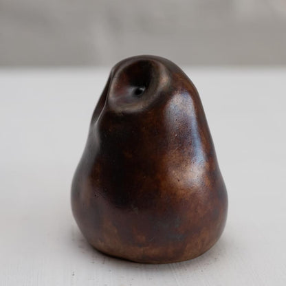 Brown coloured bronze owl sculpture against a white background - side view