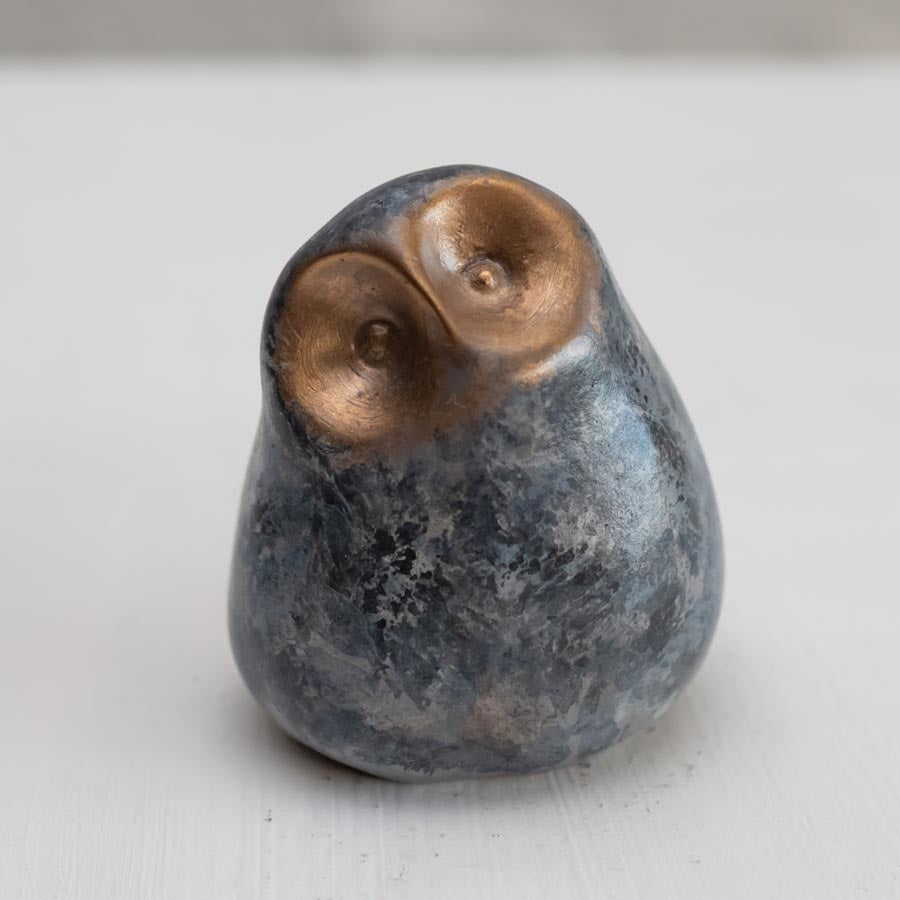 Small grey coloured bronze owl sculpture against a white background