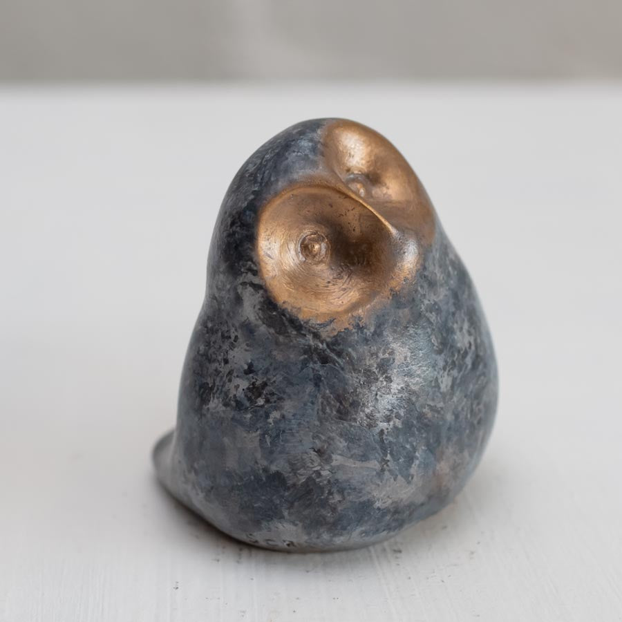 Small grey coloured bronze owl sculpture against a white background