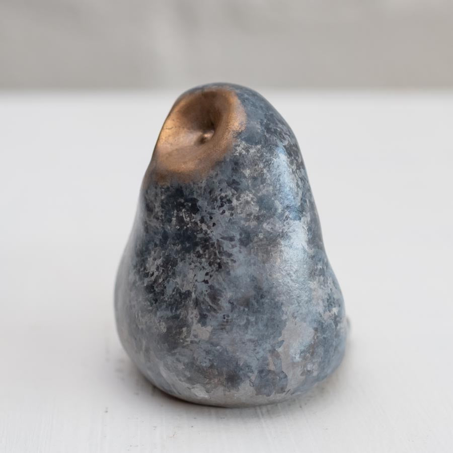 Small grey coloured bronze owl sculpture against a white background - side view