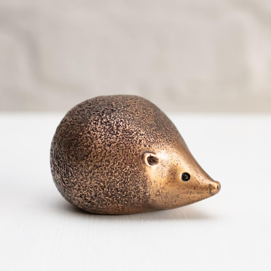 Bronze hedgehog sculpture on a white background
