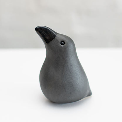 Small ceramic Raven sculpture against a white background
