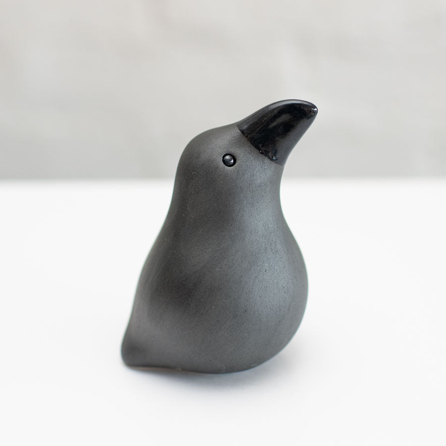 Small ceramic Raven sculpture against a white background