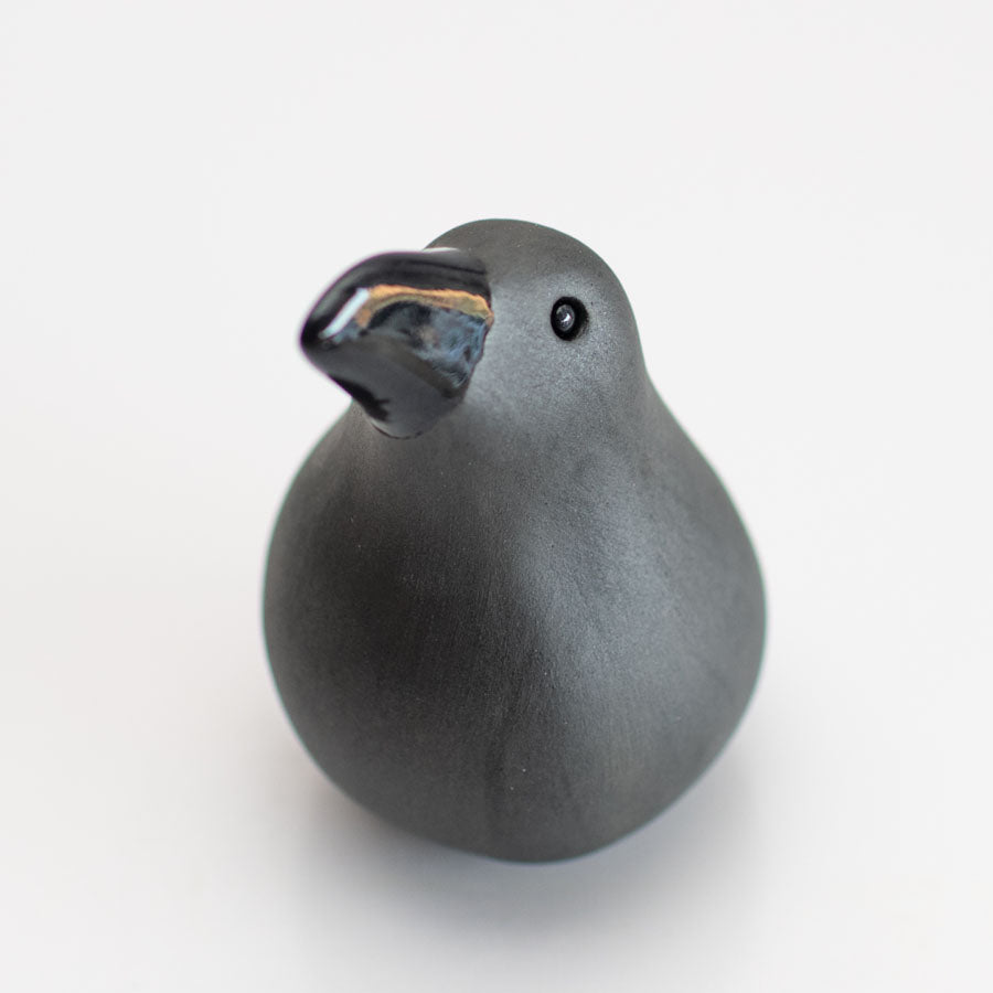 Small ceramic Raven sculpture against a white background