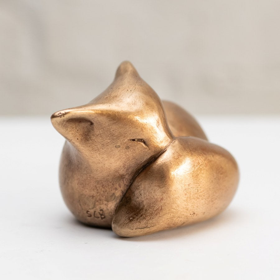 Sleepy Bronze Fox Sculpture, a small bronze fox curled up with its head resting on its body