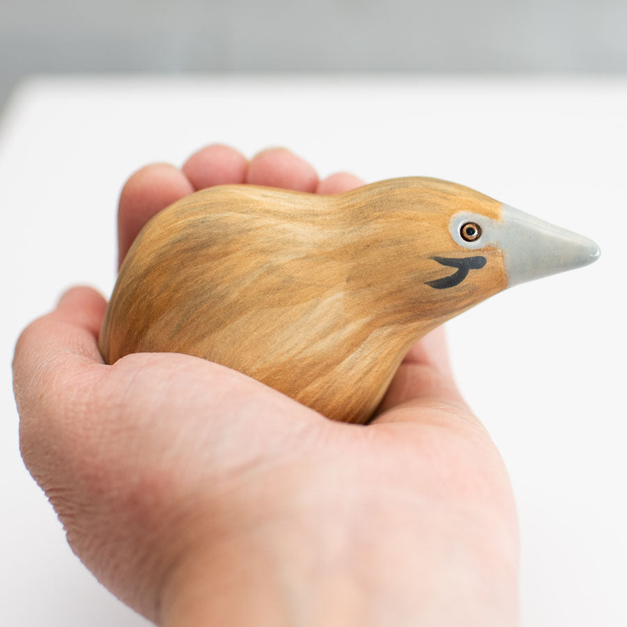 Small ceramic Bittern Sculpture in a hand against a white background