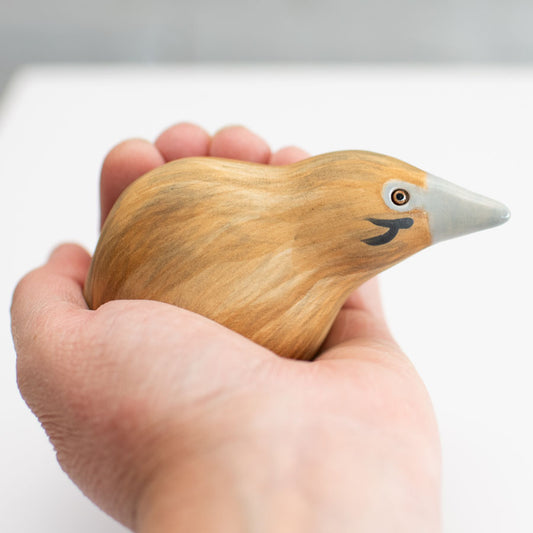 Small ceramic Bittern Sculpture in a hand against a white background