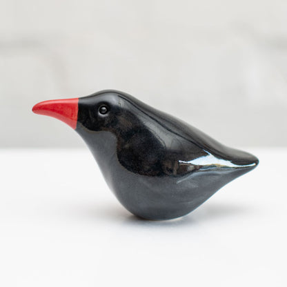 A small ceramic Chough sculpture against a plain background