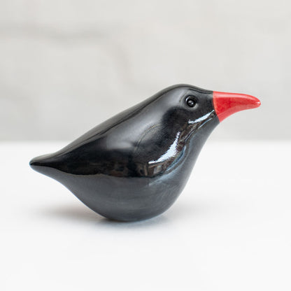 A small ceramic Chough sculpture against a plain background