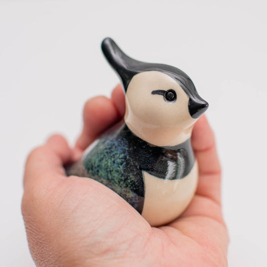 Small ceramic Lapwing sculpture in a hand