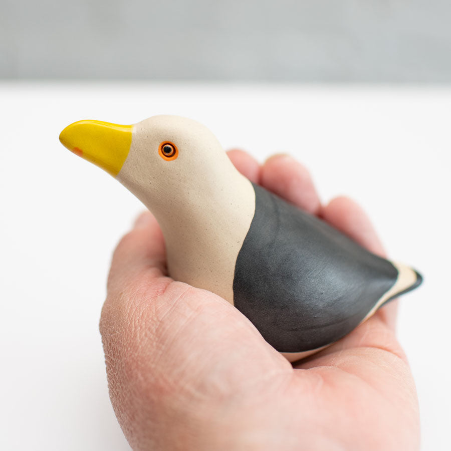 Small Ceramic Black Backed Gull sculpture in a hand