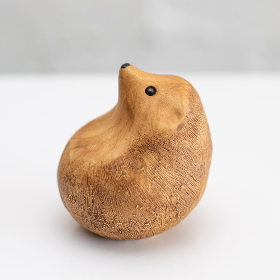 A small brown ceramic hedgehog sculpture