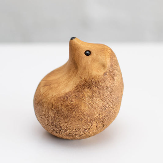 A small brown ceramic hedgehog sculpture