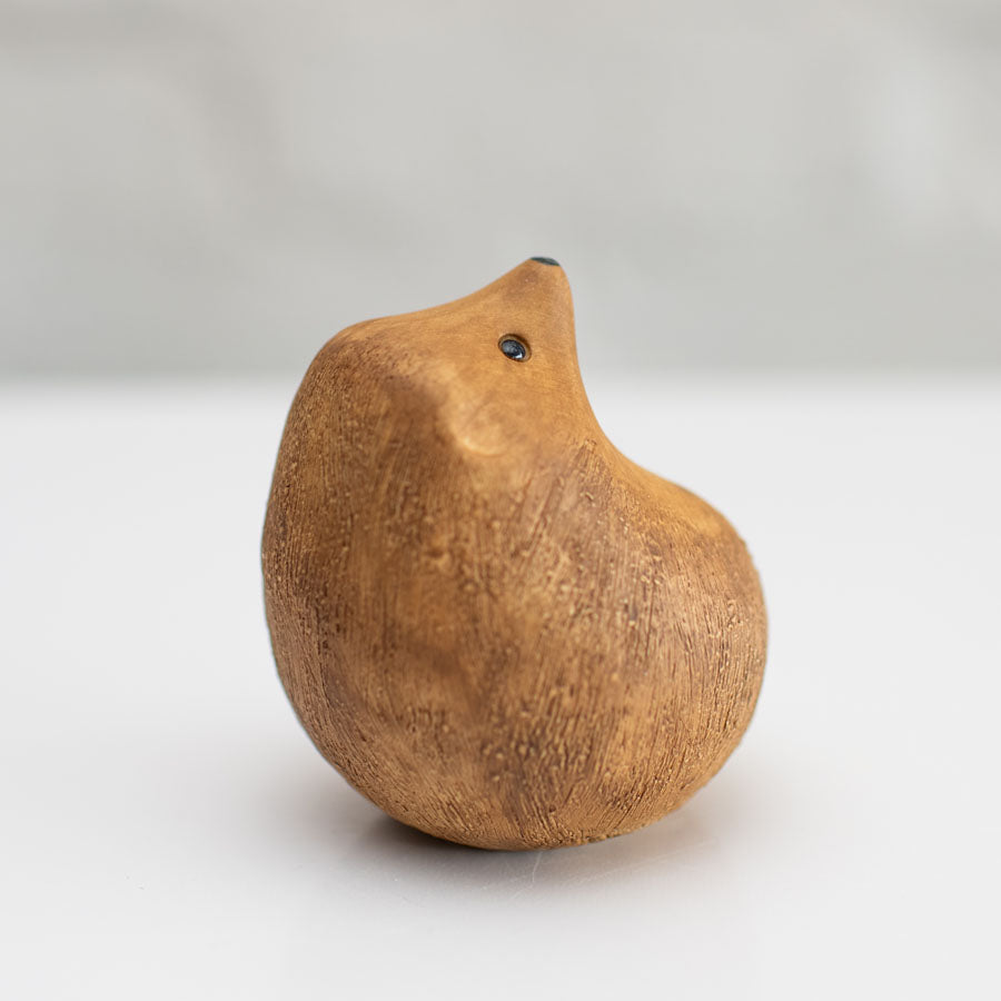 A small brown ceramic hedgehog sculpture