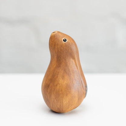A small ceramic hare sculpture in a chestnut brown colour standing on a white surface against a soft gray background.
