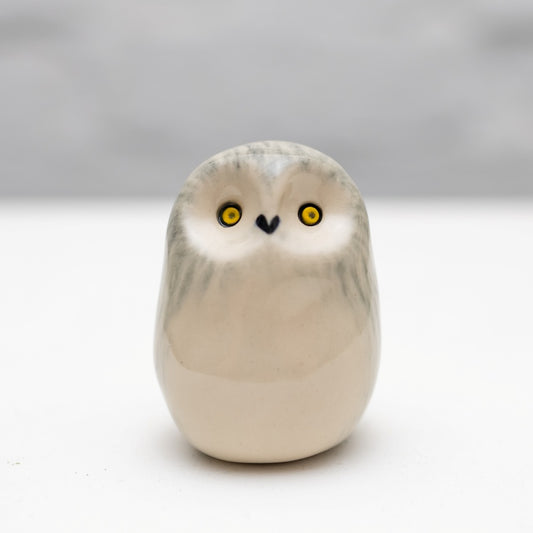 Small ceramic snowy owl sculpture on a white background