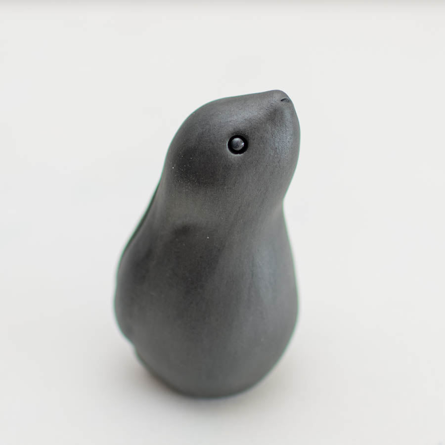 Black Moongazing Hare, a small, smooth, dark grey ceramic hare figurine with a single round eye