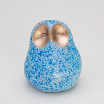 Small bronze owl with a happy facial expression in a mottled blue colour