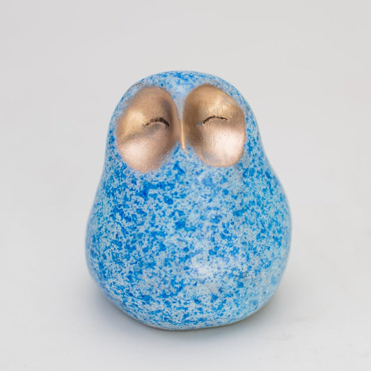 Small bronze owl with a happy facial expression in a mottled blue colour