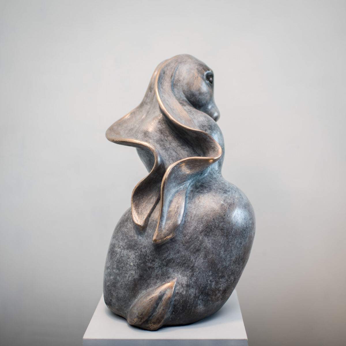 Bronze sculpture of a hare with flowing ears, viewed from the back