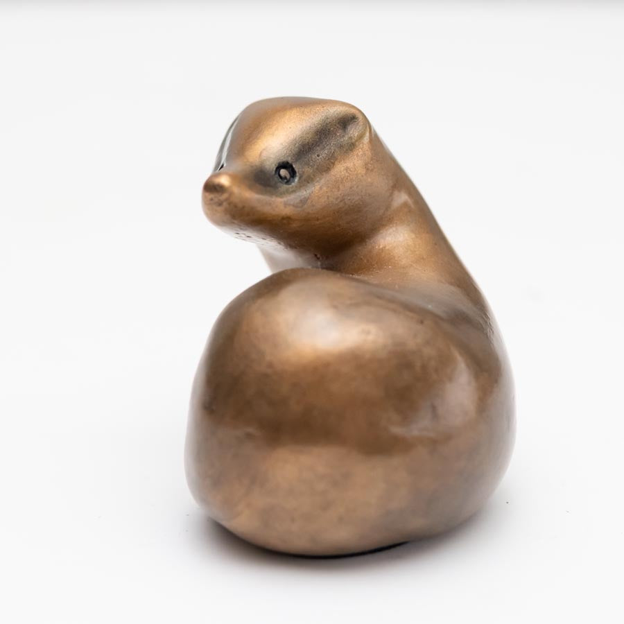 Small Bronze Curvy Badger Sculpture, a smooth, bronze-colored badger sculpture with a curved back