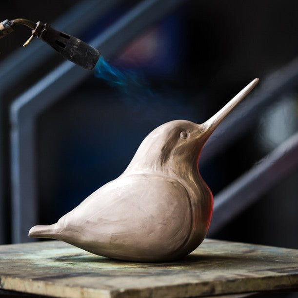 Bronze Kingfisher sculpture having heat applied