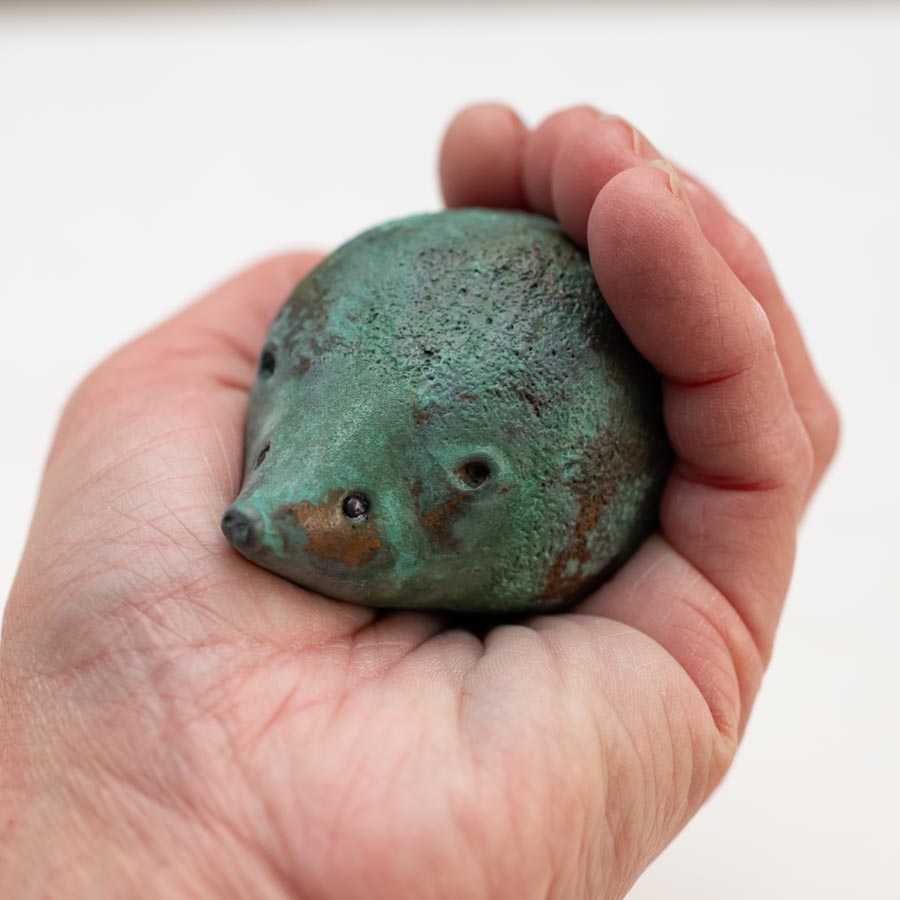 Small Foundry Cast Bronze Hedgehog Sculpture - Ancient Green held in a hand