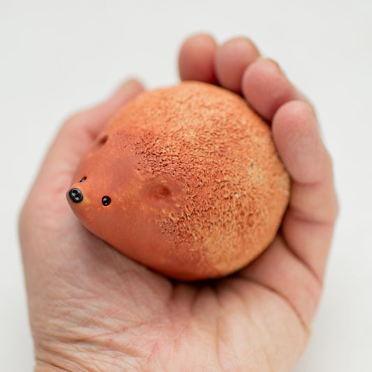 Small Tan Ceramic Hedgehog Sculpture held in a hand