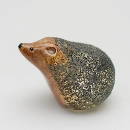 Small ceramic hedgehog on a plain background