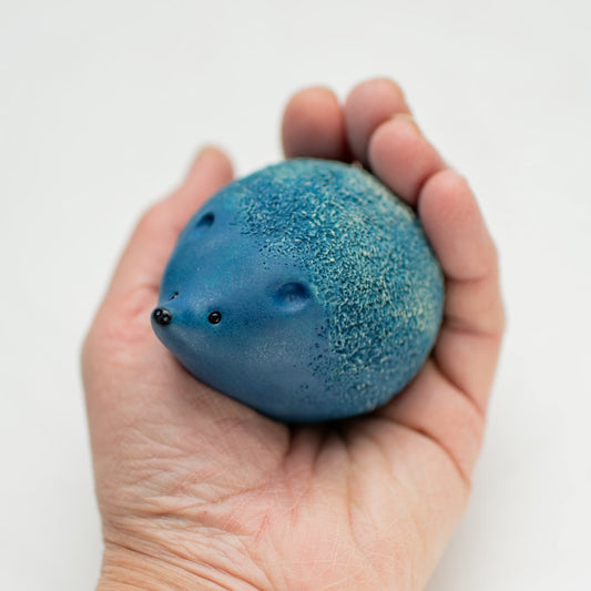 Small Blue Ceramic Hedgehog Sculpture held in a person's palm