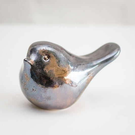 A tactile ceramic bird in a mottled decorative bronze metallic glaze