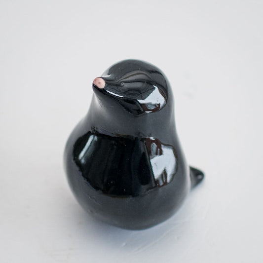 A ceramic mole with a little pink nose and a glossy black coat