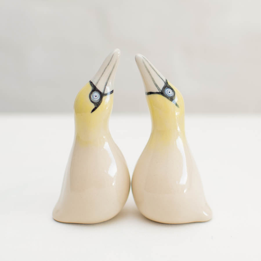 Small Ceramic Gannet Sculpture Set, two yellow and white ceramic birds with black eyes and beaks