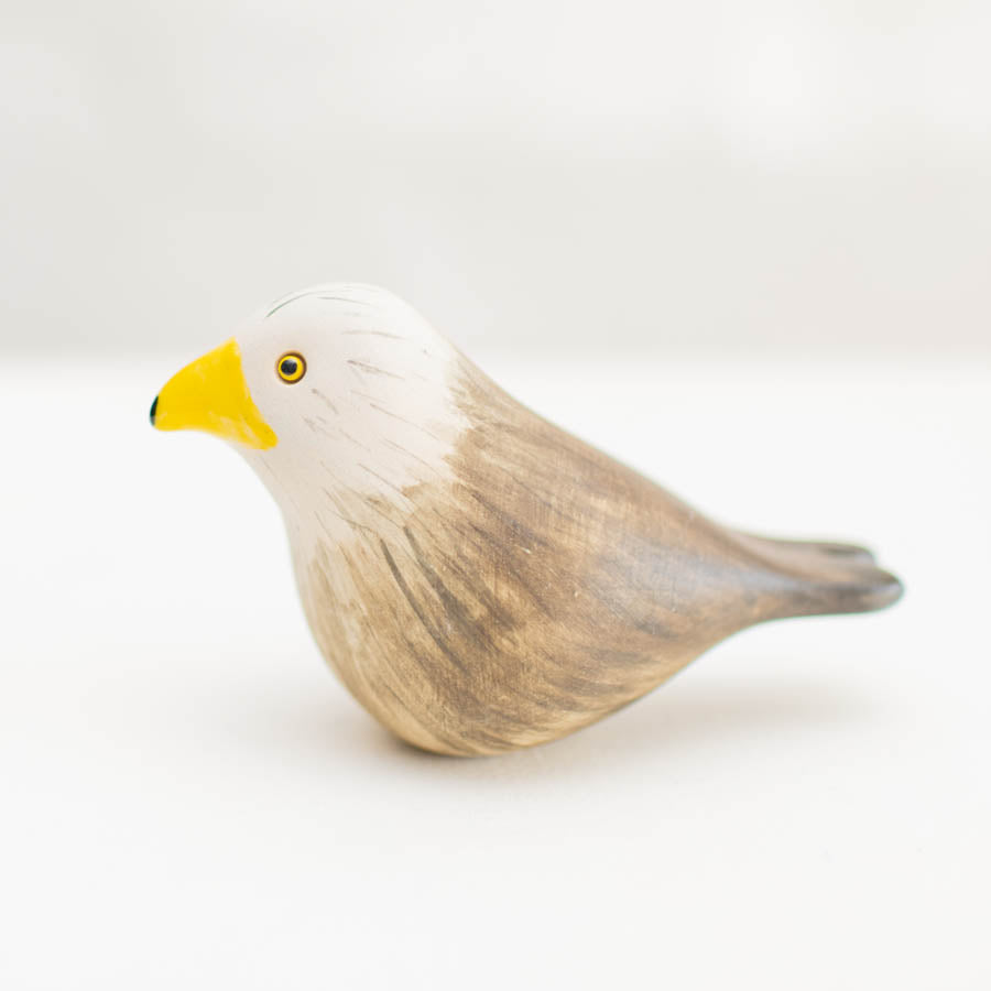 Ceramic Red Kite, a small bird figurine with a white head, brown body, and yellow beak