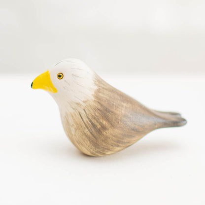 Ceramic Red Kite, a small bird figurine with a white head, brown body, and yellow beak