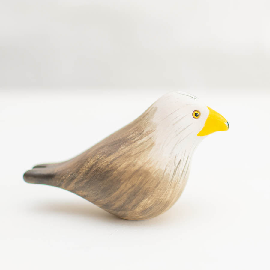 Ceramic Red Kite, a small bird figurine with a white head, yellow beak, and brown body
