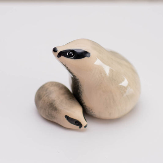 A small badger sculpture of parent and cub against a white background