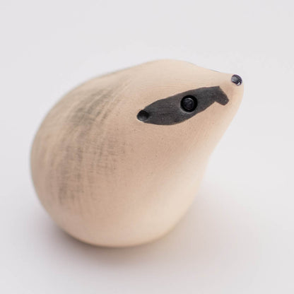 A small badger sculpture against a white background