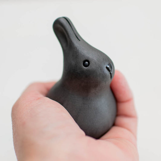 Black Baby Bunny ceramic figurine held in a hand