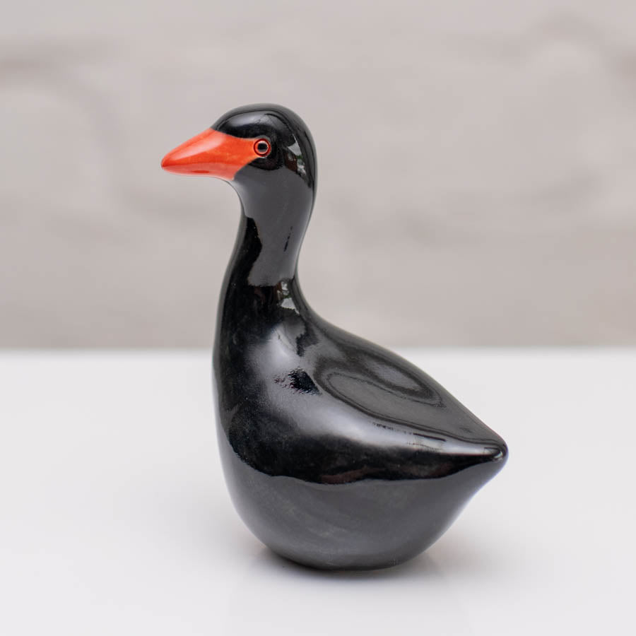 Small ceramic black Swan sculpture against a white background