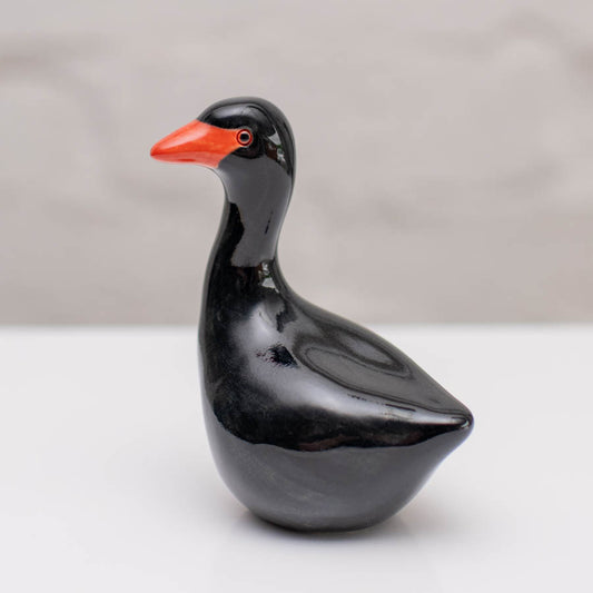 Small ceramic black Swan sculpture against a white background