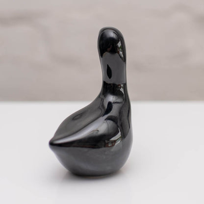 Small ceramic black Swan sculpture against a white background