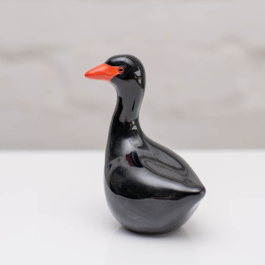 Small ceramic black Swan sculpture against a white background