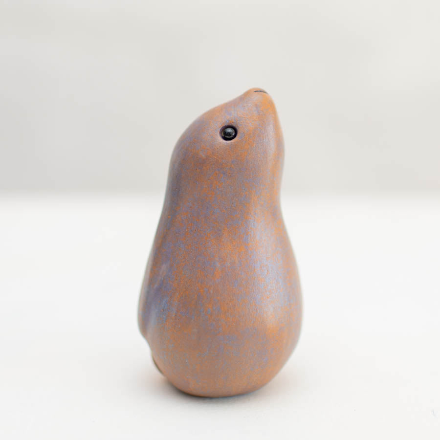 Multi coloured moongazing Hare, a ceramic sculpture with a smooth, mottled brown and purple surface