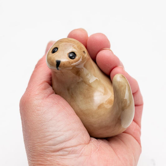 Small Ceramic Curly Otter Sculpture held in a person's hand